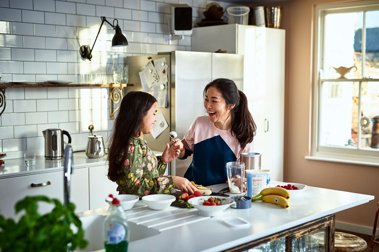 Mother teasing daughter in kitchen