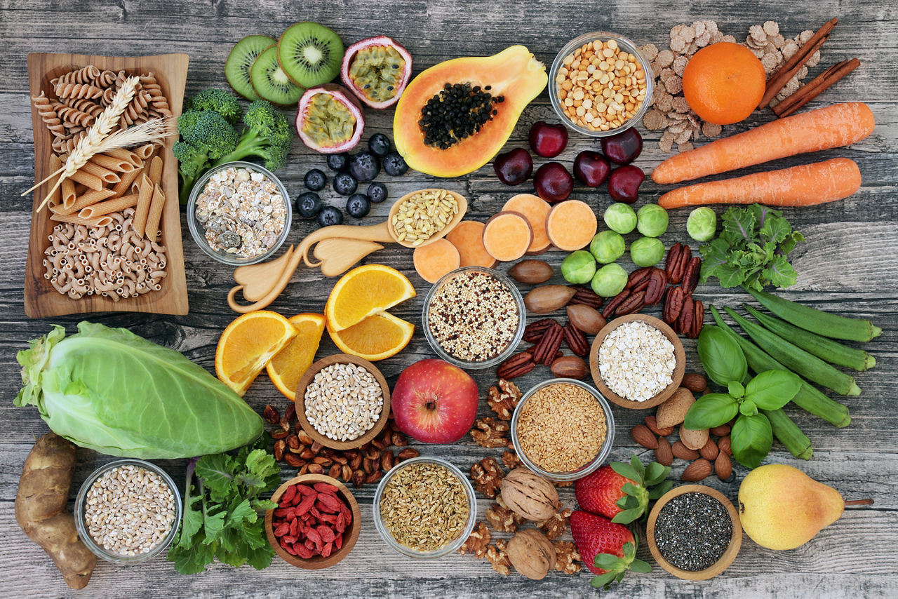 Alimentos veganos ricos en fibra dietética y que estimulan el sistema inmunológico con frutas, verduras, pasta integral, legumbres, cereales, nueces y semillas con alimentos ricos en omega 3, antioxidantes, antocianinas y vitaminas.