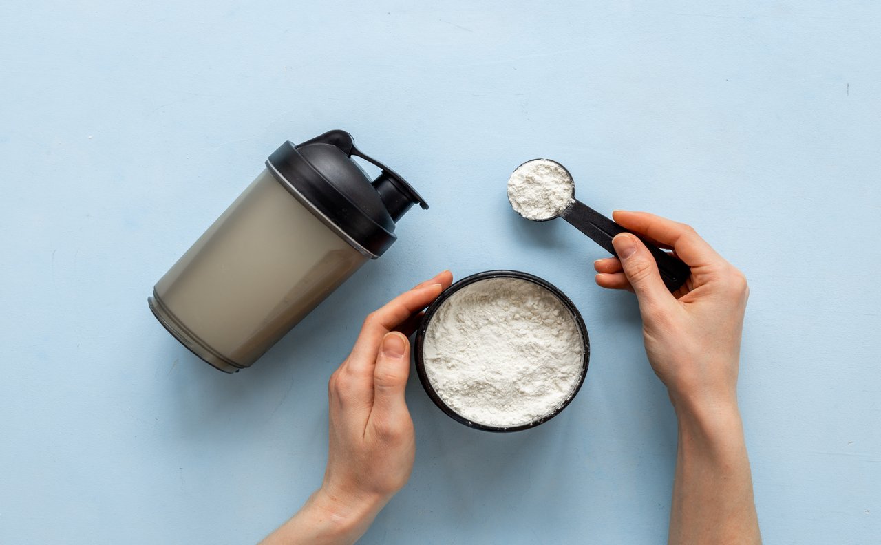 Hands making shake with whey protein. Fitness and gym diet nutrition