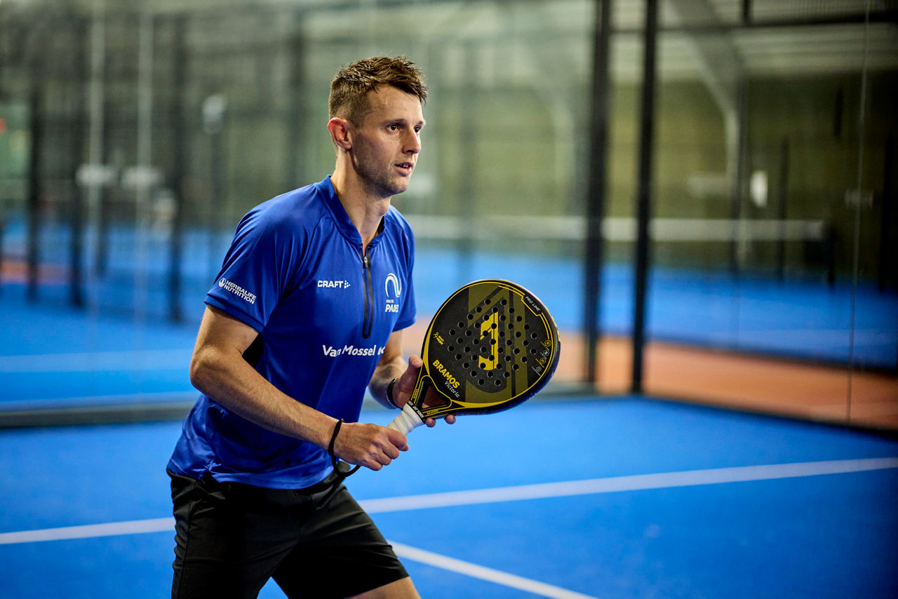 Afbeelding van Bram Meijer, door Herbalife gesponsorde atleet, met een padel in de hand