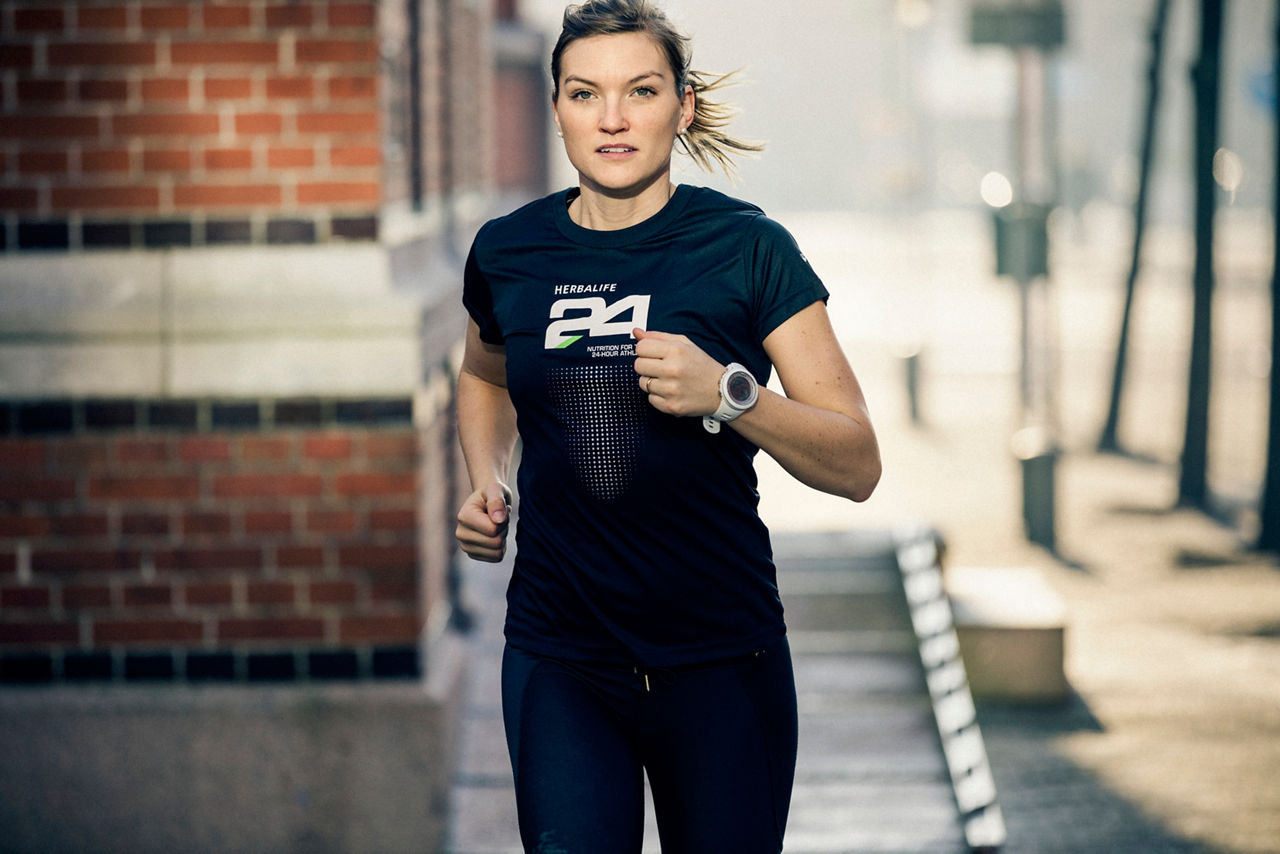 Et bilde av Åsa Lundström, Herbalife-sponset idrettsutøver, som løper og har på seg en T-skjorte med Herbalife24®-logoen.