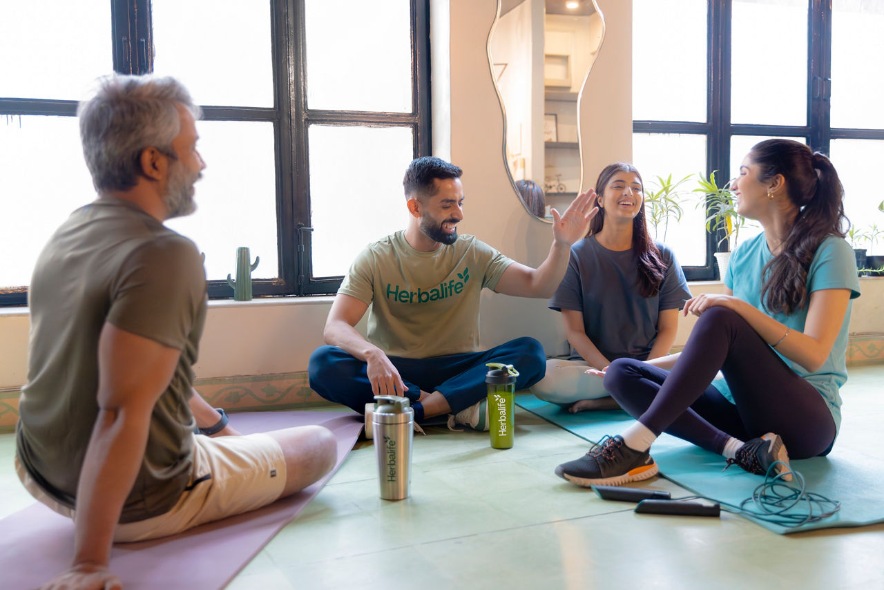 A group of friends in a yoga studio laughing