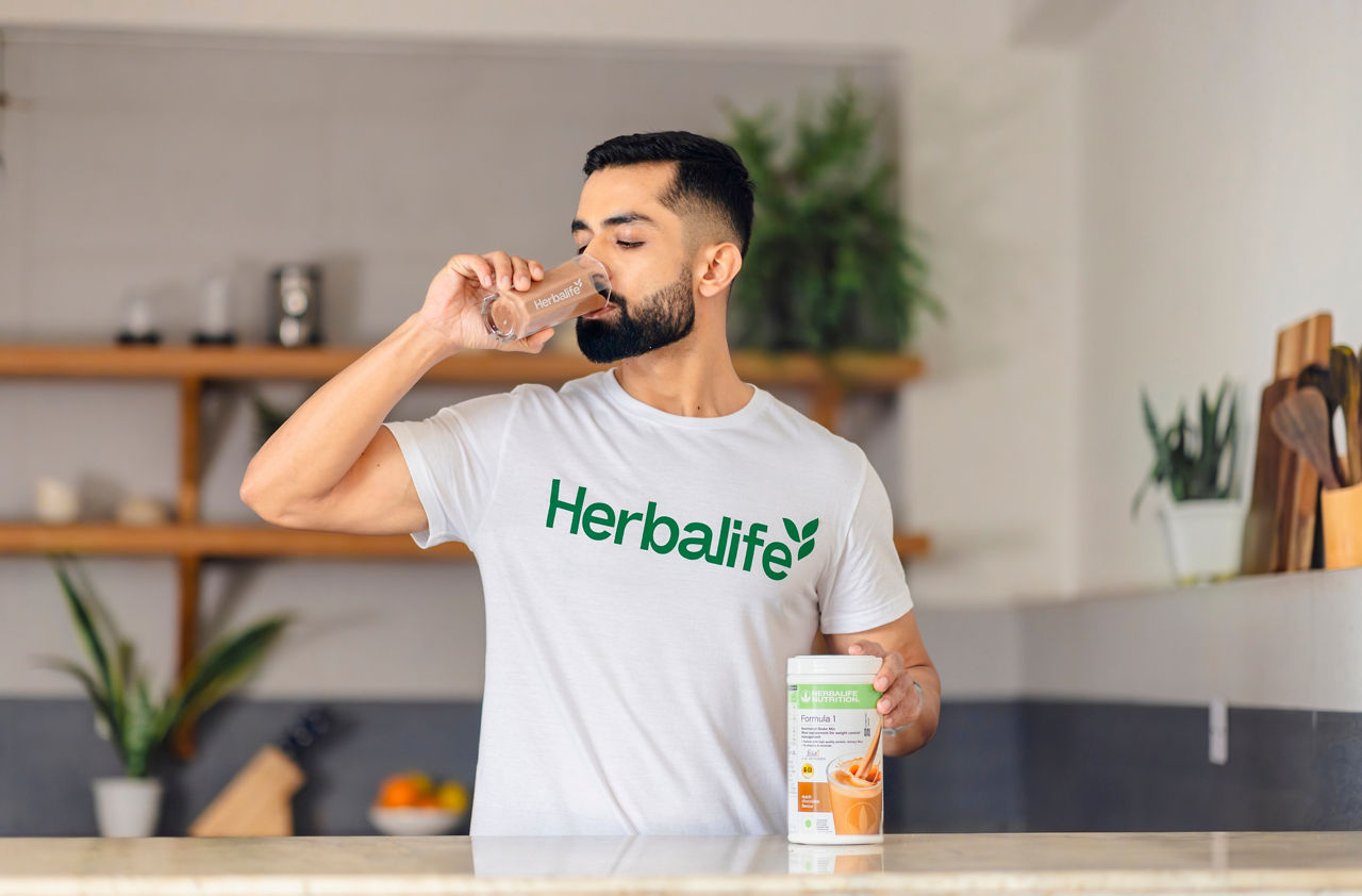 Man drinking a Formula 1 shake in the kitchen