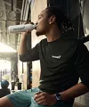 Man drinking from white bottle at the gym