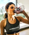 Woman drinking sports drink indoors