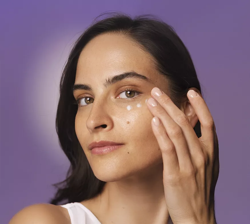 Μια γυναίκα εφαρμόζει την HL/Skin Nourishing Eye Cream στο πρόσωπό της.