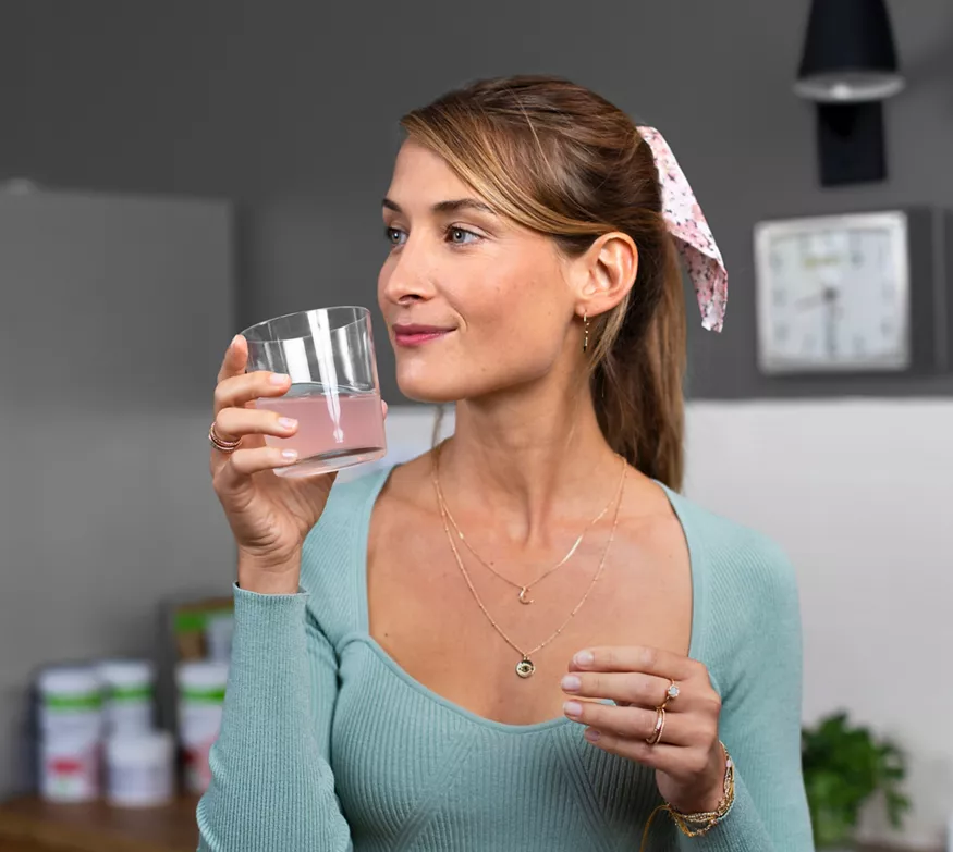 Woman drinking collagen drink at home