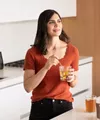 Femme dans la cuisine avec un verre de concentré d'aloès