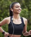 Smiling woman with headphones in on run in the park