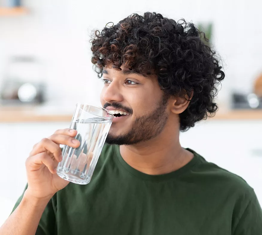 Happy man drinking a glass of water