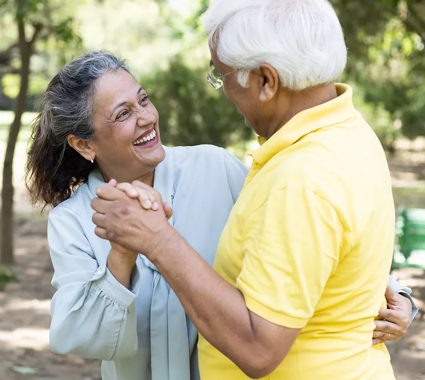 Older couple smiling and embracing in the park