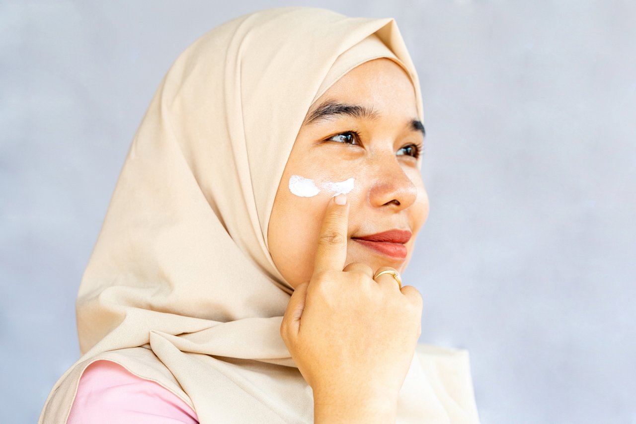 Woman applying facial cream